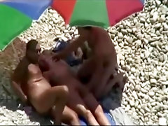 Threesome sex fun on public beach caught on voyeur cam